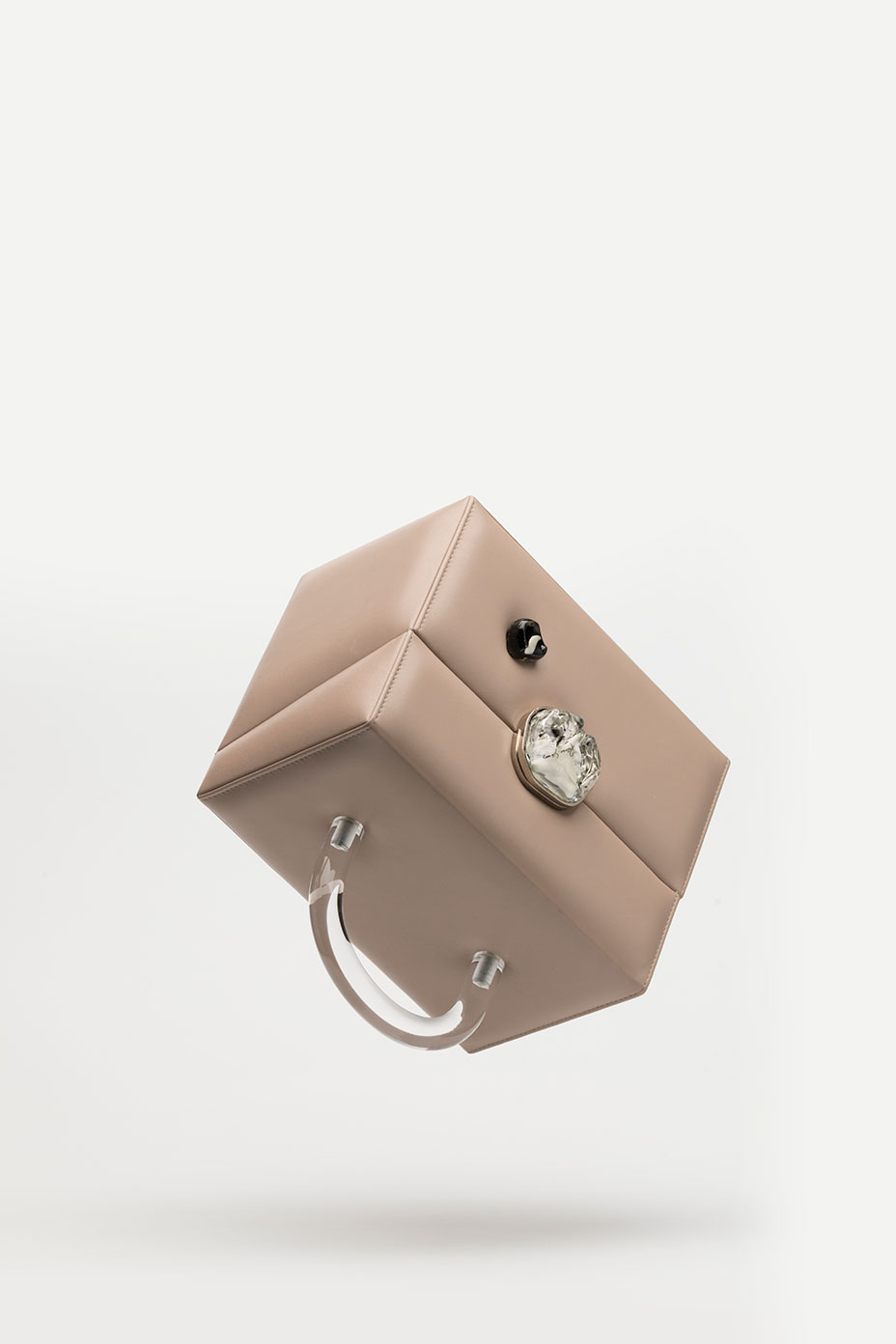 The Box bag in beige leather is turned and is floating in the air on a white background