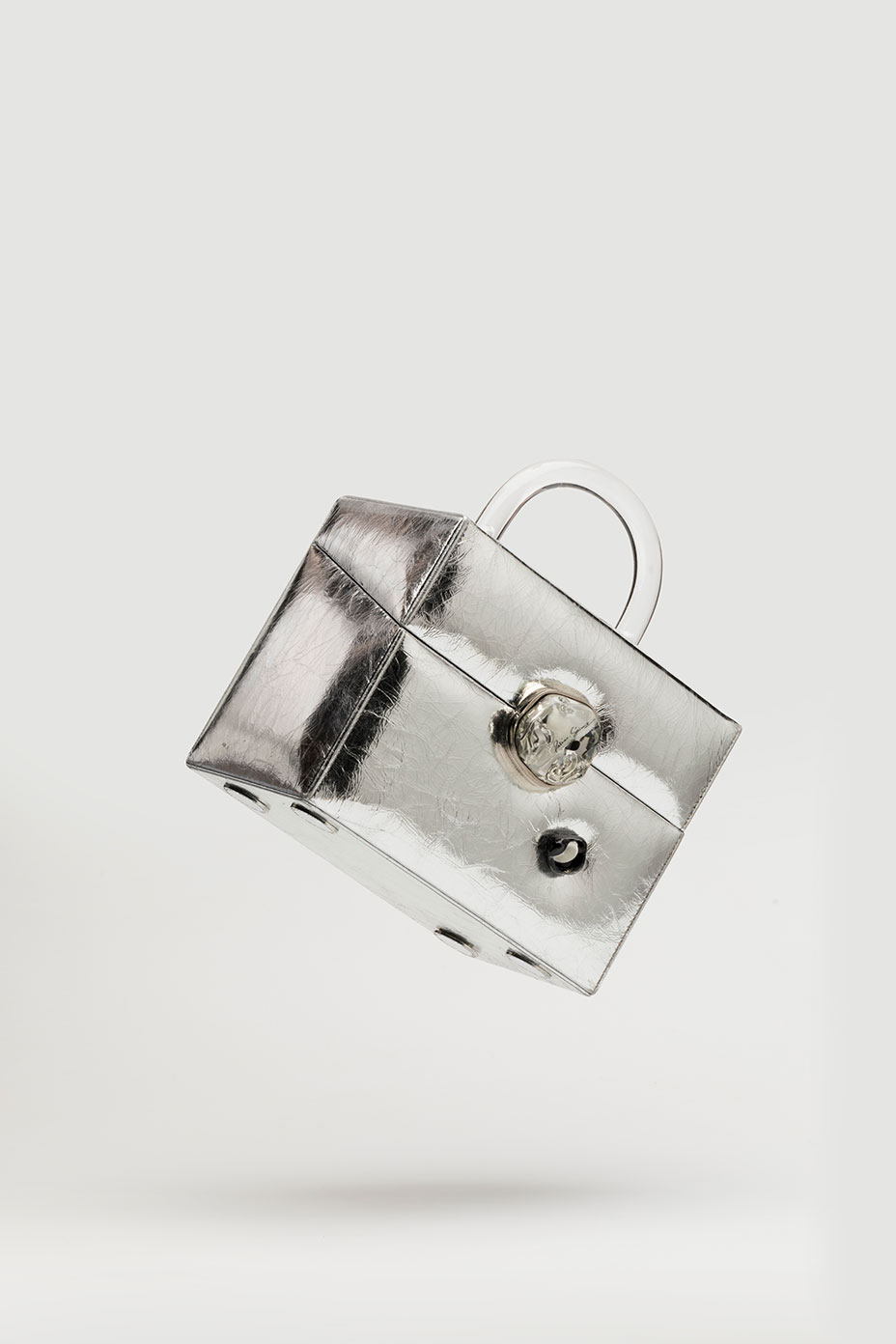 The Box bag in Silver leather is turned and is floating in the air on a white background